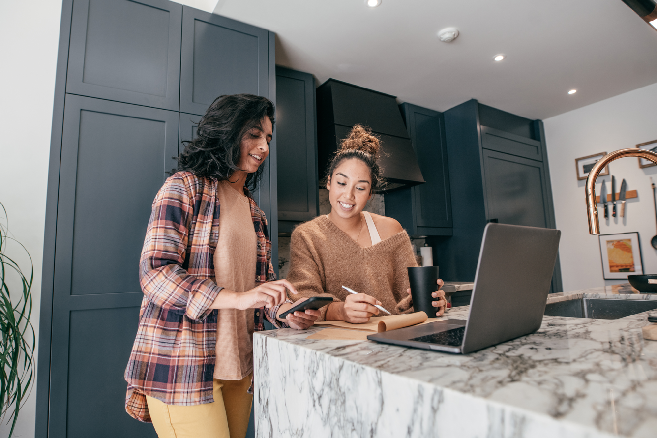 Two young women sitting at the kitchen table.