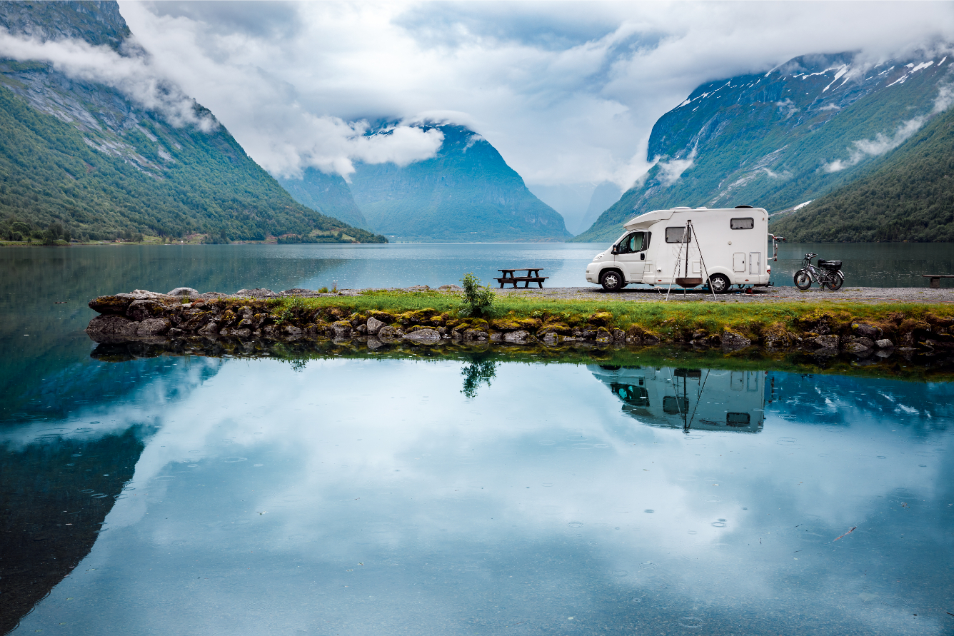 RV and Motorcycle in front of a mountain and lakes