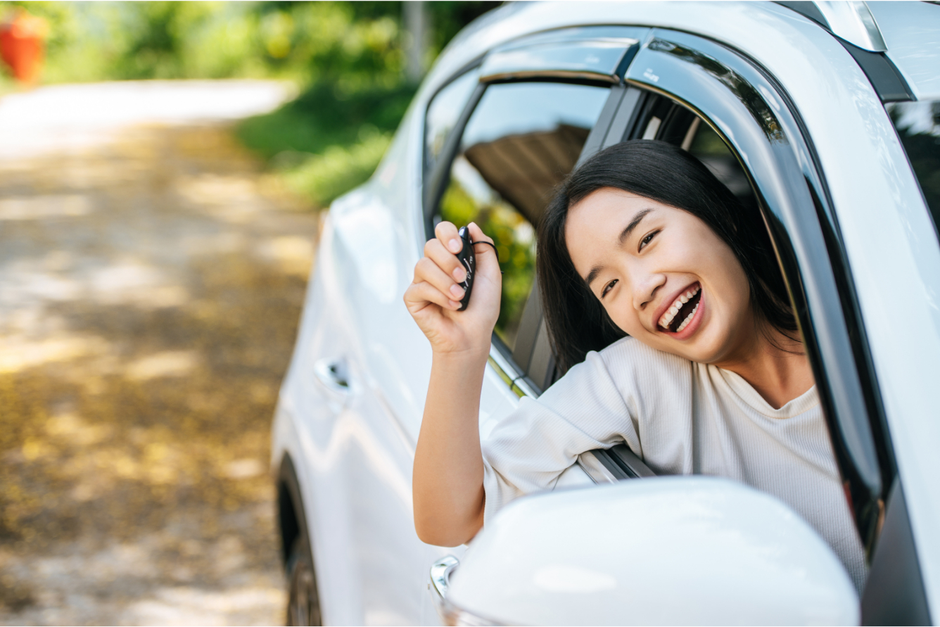 Woman leaning out her car showing keys.