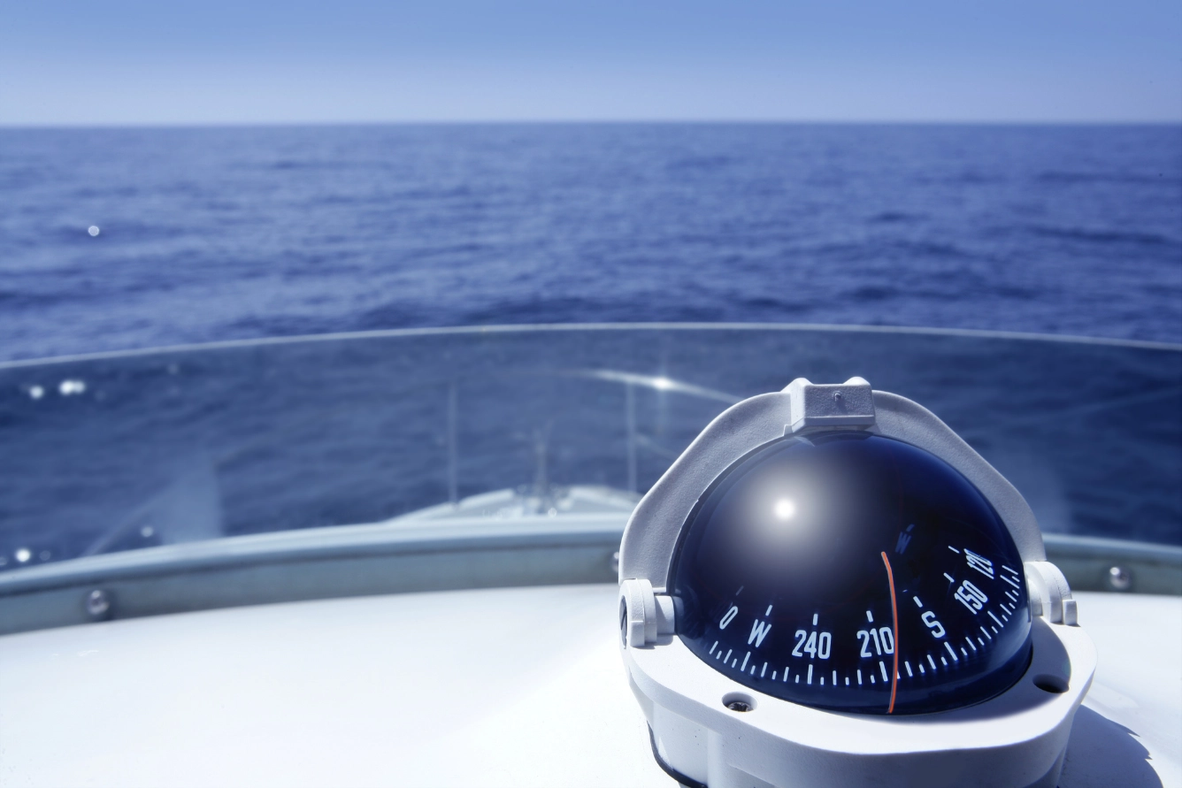 Circular compass on the deck of a leisure boat.