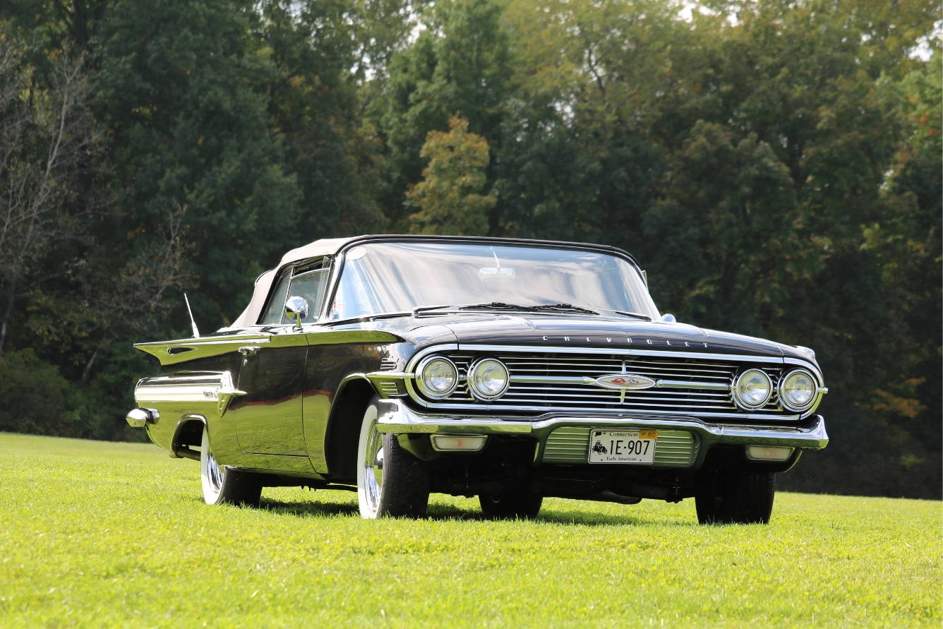Black classic car on a grassland.