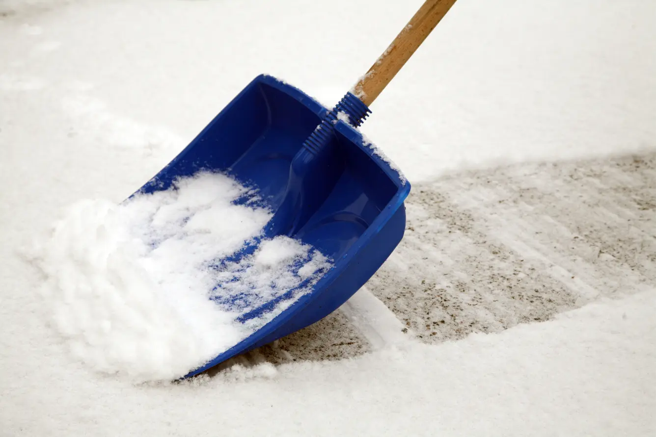 Shoveling a walkway as part of winter-proofing your home.