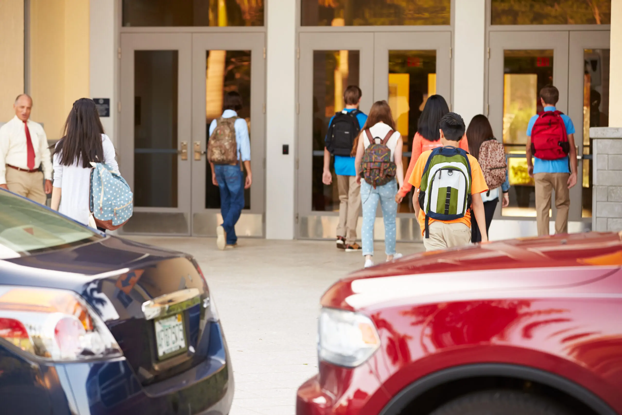 Group of high school teenage students standing in front of a school door, chatting capturing the energy and excitement of student life.