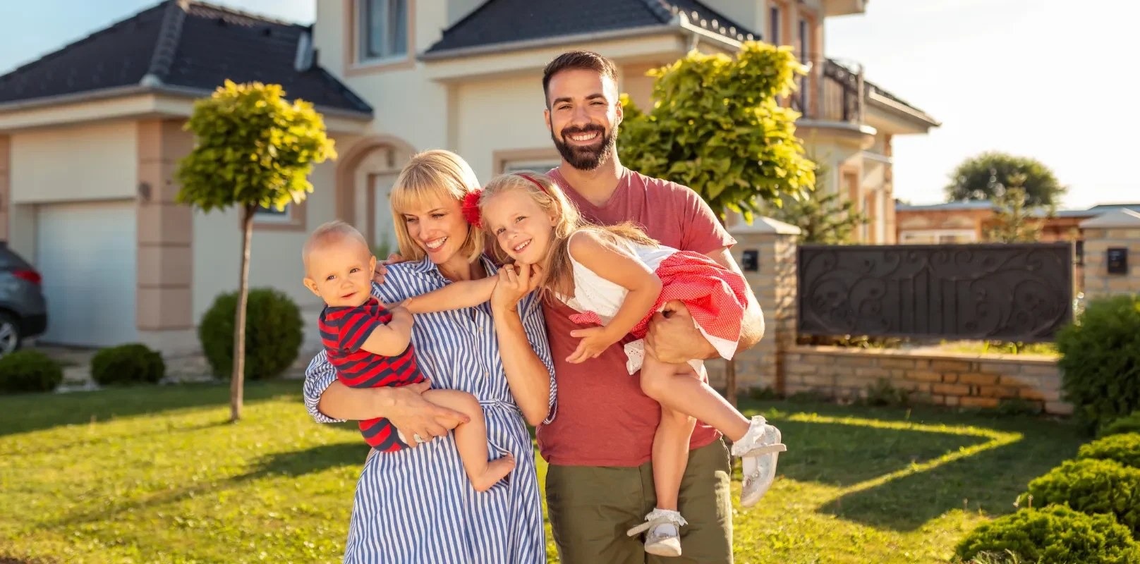 A family standing happily in front of their home, feeling safe and secure under the protection of comprehensive insurance.