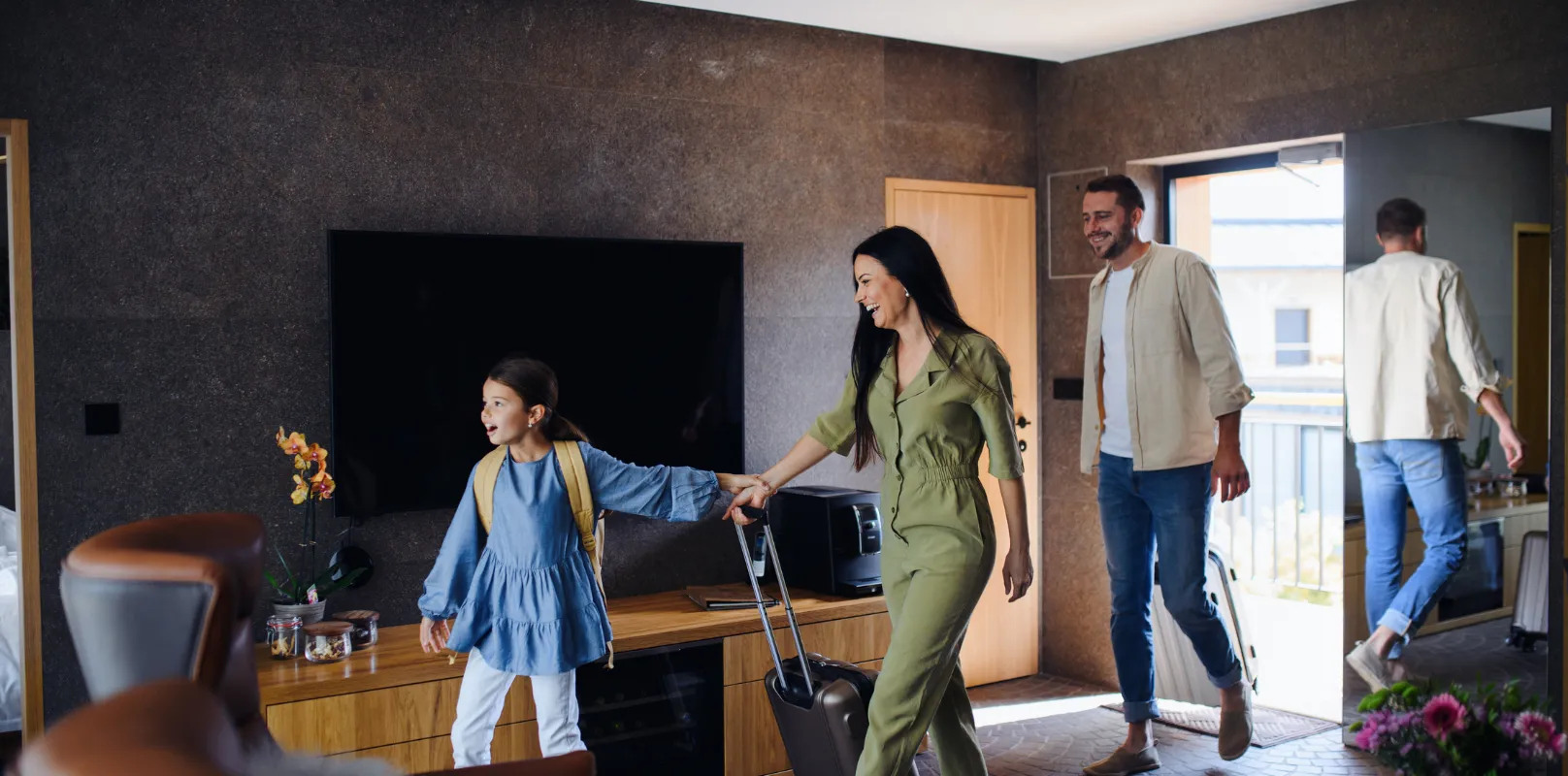 A joyful family entering and moving into a rental property, highlighting the value of rental property insurance for a safe and secure move-in experience.