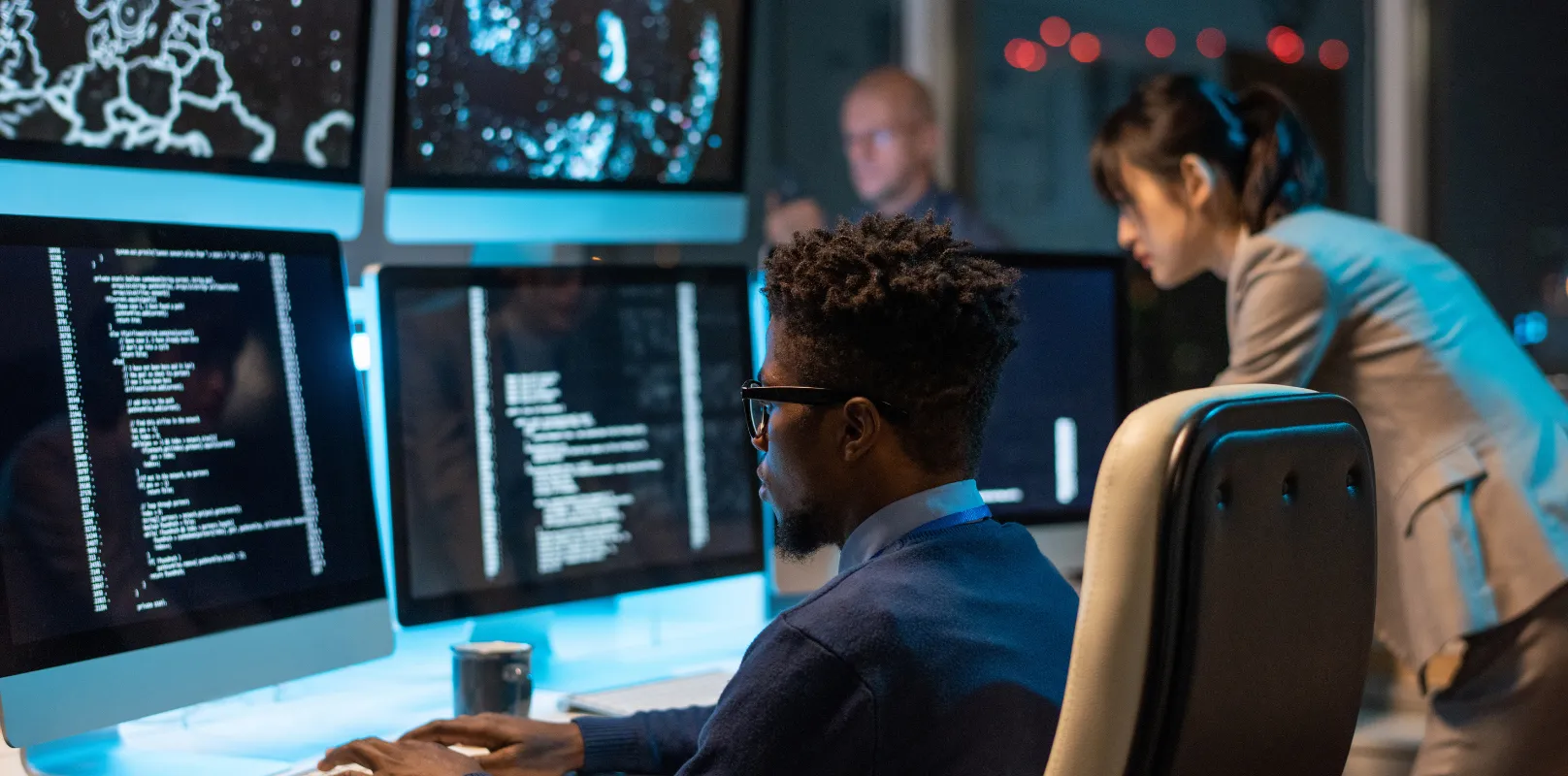 Office professionals working with computers and data, representing cyber risk assessment and cybersecurity insurance coverage. <br />