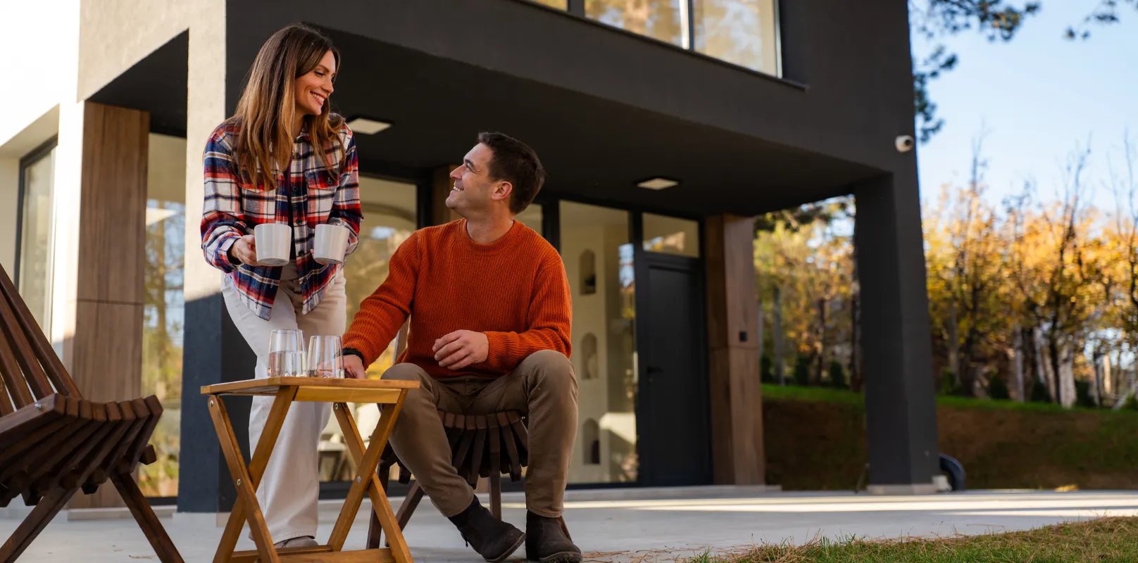 Couple sitting outside of their house enjoying spring knowing their house is covered with home insurance.