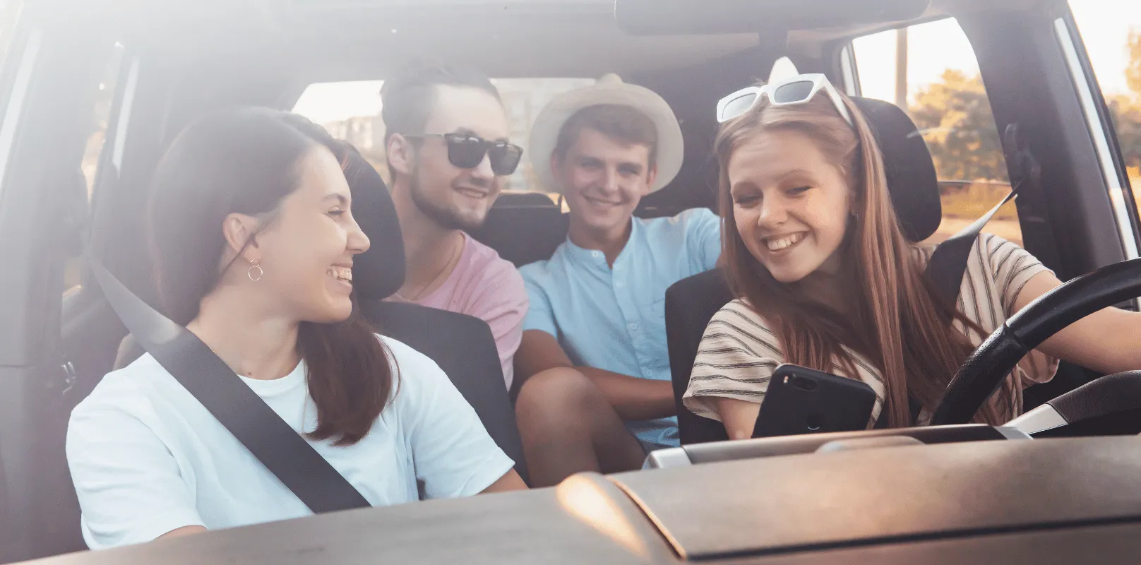 Group of passengers seated inside a vehicle with one person positioned in the driver’s seat.